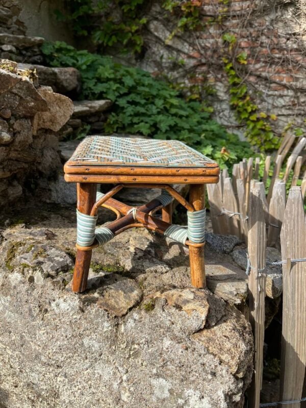 "Tabouret en rotin utilisé comme repose-pieds dans un salon cosy"